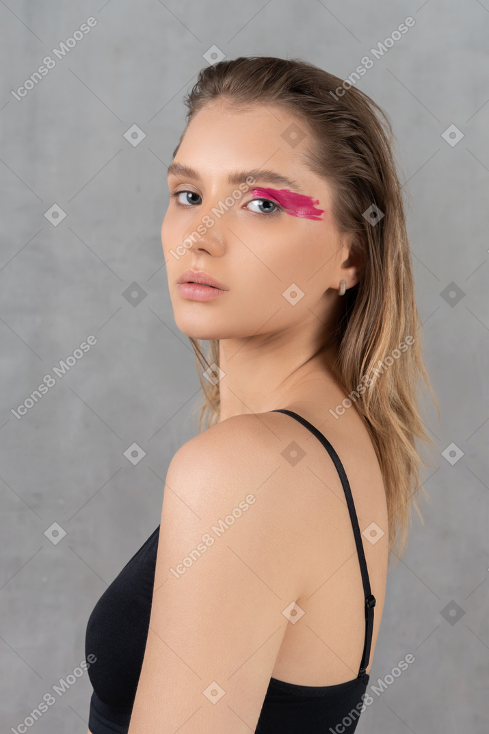 Vista lateral de una mujer joven con maquillaje de ojos audaz