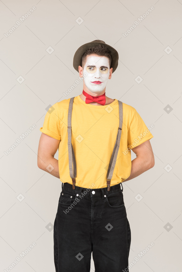 Male clown standing with his hands behind his back