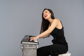 Cheerful woman laughing out loud while playing a piano