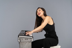 Mujer alegre riendo a carcajadas mientras toca un piano