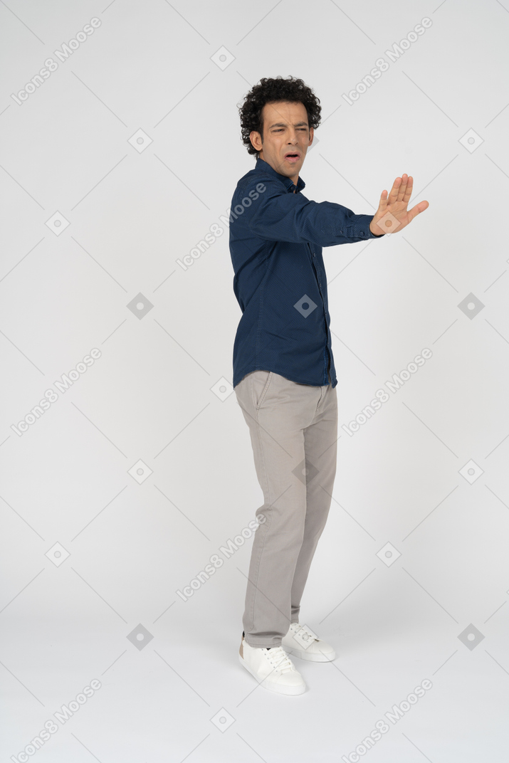 一个穿着休闲服的男人的前视图显示停止手势
