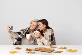 Junge frauen, die kaffee trinken und selfie machen