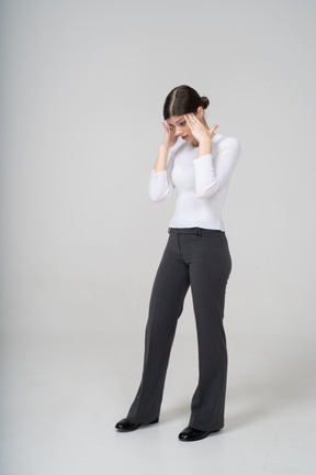 Front view of a young woman touching her head