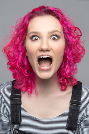 Overwhelmed excited girl with curly pink hair