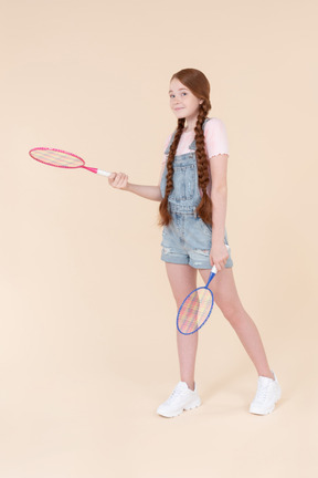 Teenage girl holding two rackets
