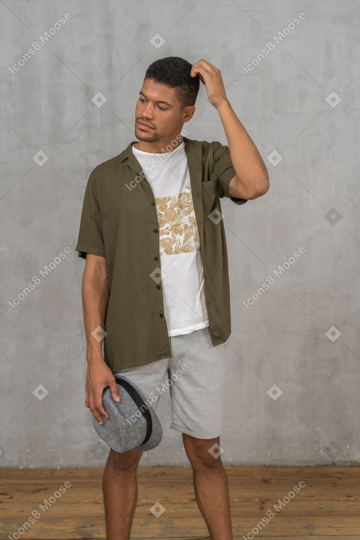 Vista frontal de un joven pensativo con ropa informal.