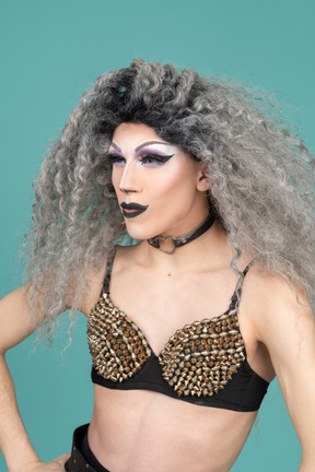 Drag queen de sutiã com tachas parecendo confiante