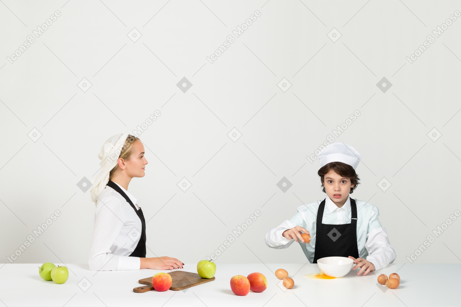 An attractive teen learning to cook under his mother's supervision