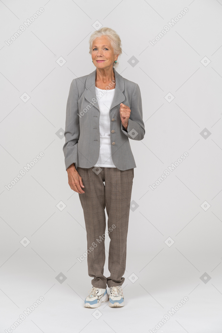 Vorderansicht einer alten dame im anzug mit blick in die kamera