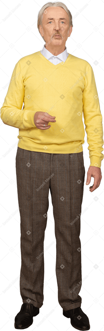 Front view of a puzzled old man in a yellow pullover raising hand and looking at camera
