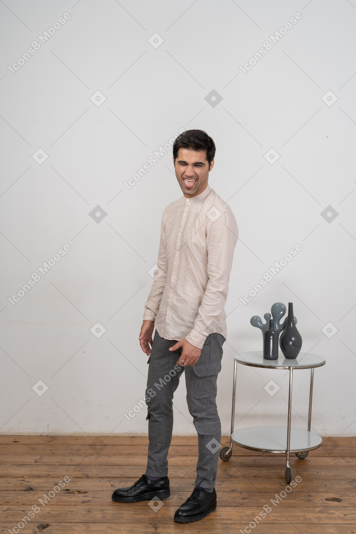 Vista frontal de un hombre feliz en ropa casual haciendo muecas