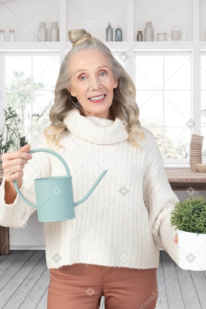 A woman holding a watering can in her hands