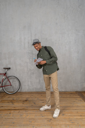 Homme prenant des notes dans un cahier et souriant