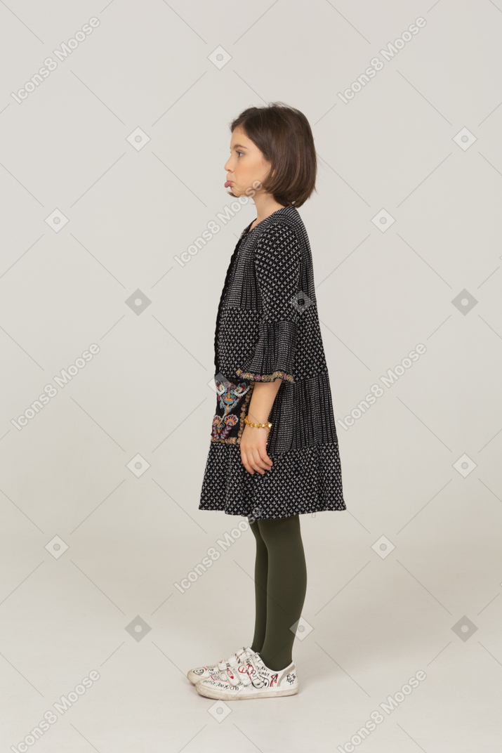 Side view of a pouting little girl in dress
