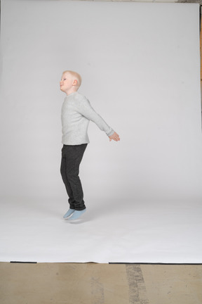 Vista lateral de um menino pulando
