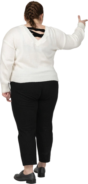 Rear view of a plump woman in casual clothes pointing with a finger