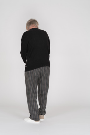 Back view of elderly man in dark clothes