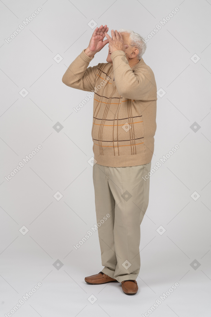 Old man in casual clothes looking up