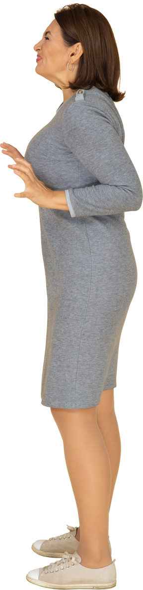 Vista laterale di una donna in abito grigio che gesticola