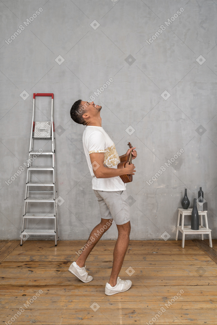 Side view of a man rocking out on ukulele