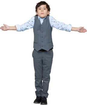 Vista frontal de um menino de terno cinza em pé com os braços estendidos