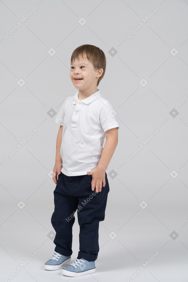 Niño pequeño de pie y sonriendo ampliamente