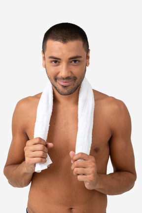 Contented barechested young man holding shower on his neck