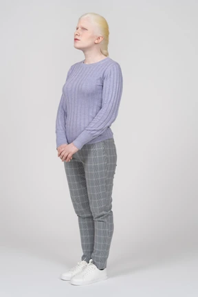 Three-quarter view of a young woman in casual clothes looking upward