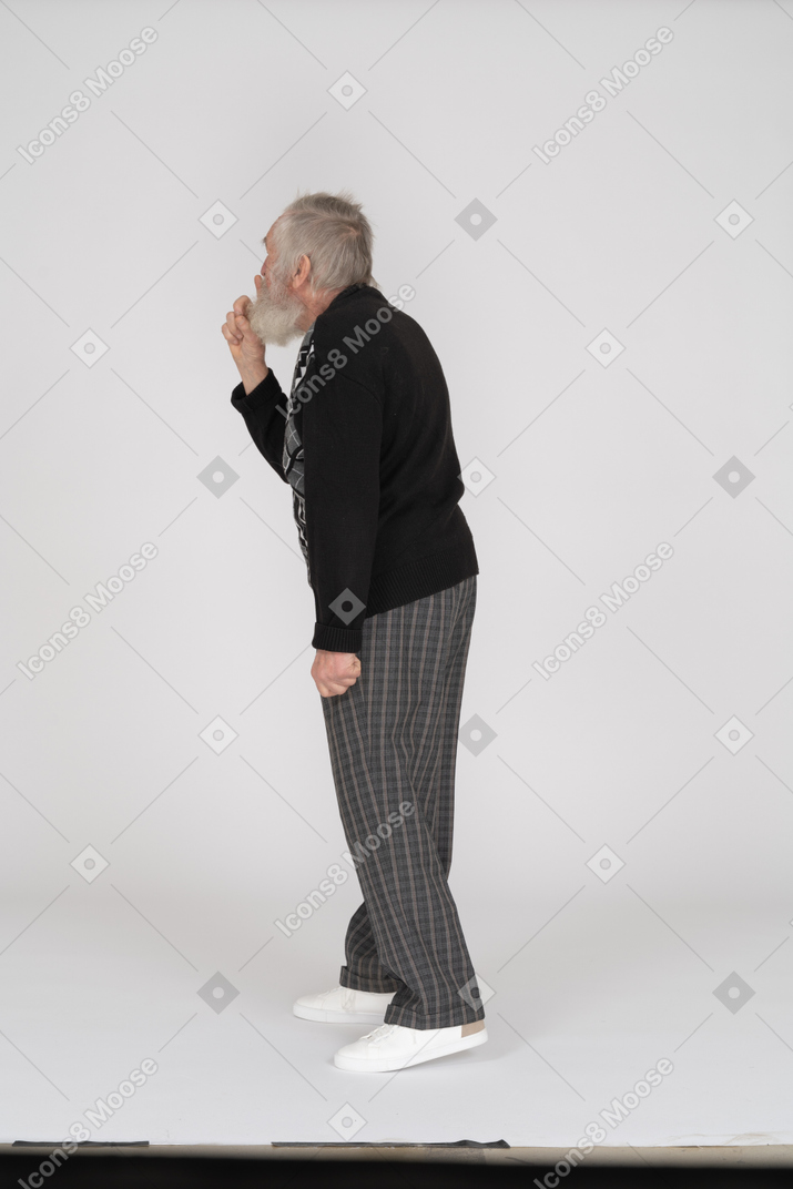 Side view of old man showing silence gesture