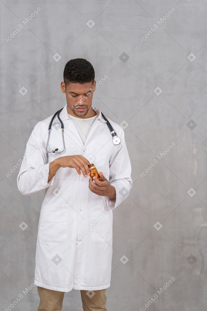 남자 의사가 병에서 약을 꺼내는 모습