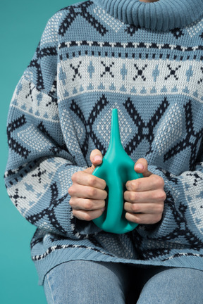 A woman holding an enema bottle