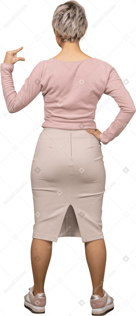 Vue arrière d'une femme en vêtements décontractés montrant la petite taille de quelque chose