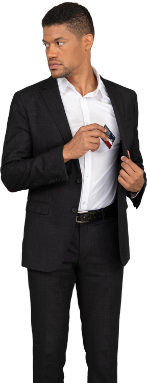Vue de face d'un jeune homme en costume noir tenant une carte bancaire