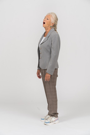 Side view of a sleepy old lady in suit yawning