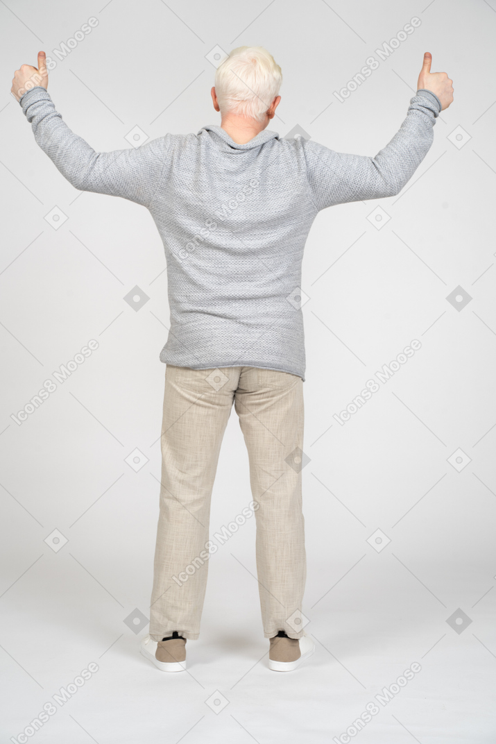 Rear view of man giving thumbs up with two hands