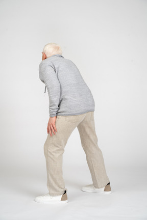Vista posteriore di un uomo in piedi con il ginocchio piegato