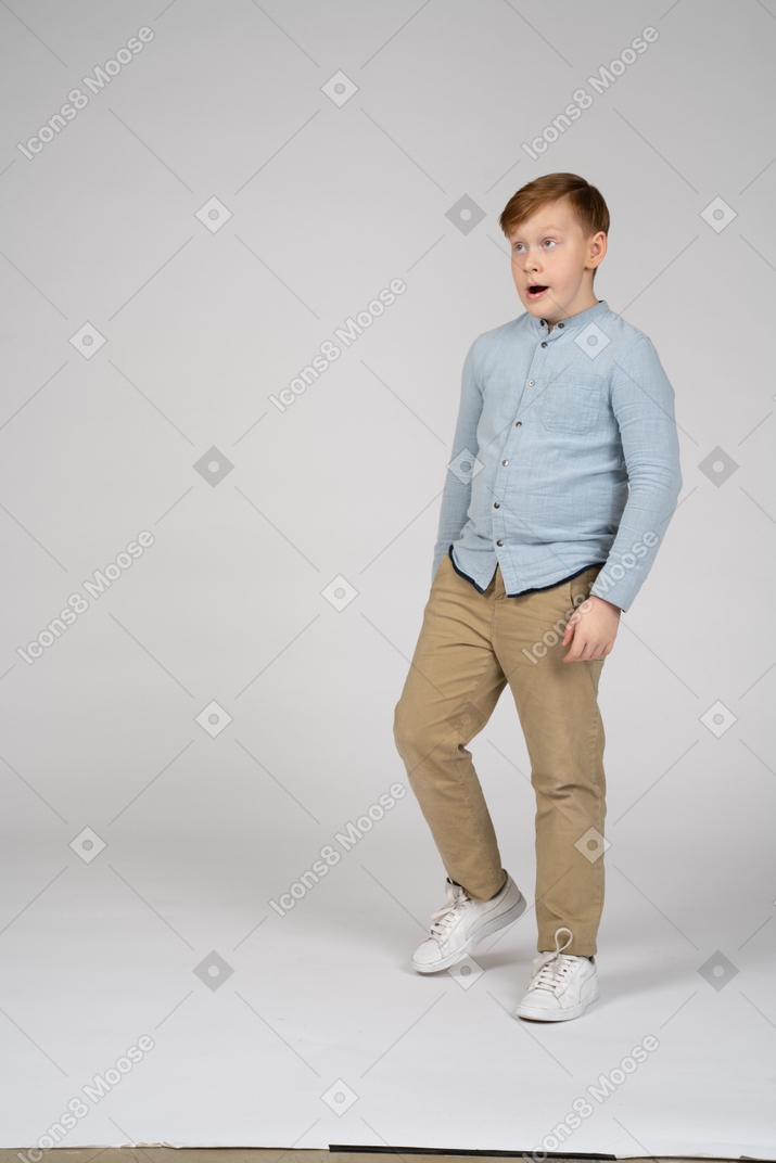 Standing boy in blue shirt is surprised