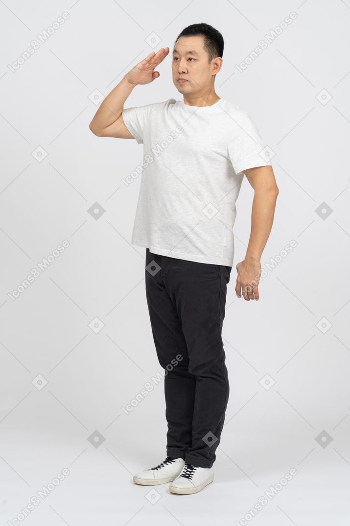 Three-quarter view of a man in casual clothes saluting with hand