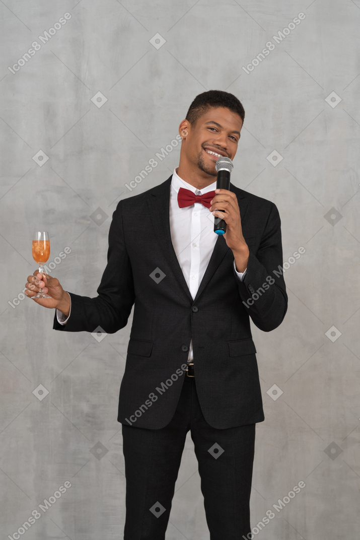 Man holding mic and flute glass giving a toast