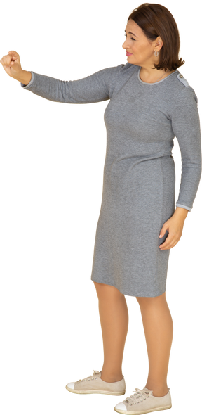 Vista lateral de uma mulher em um vestido cinza mostrando um tamanho pequeno de algo