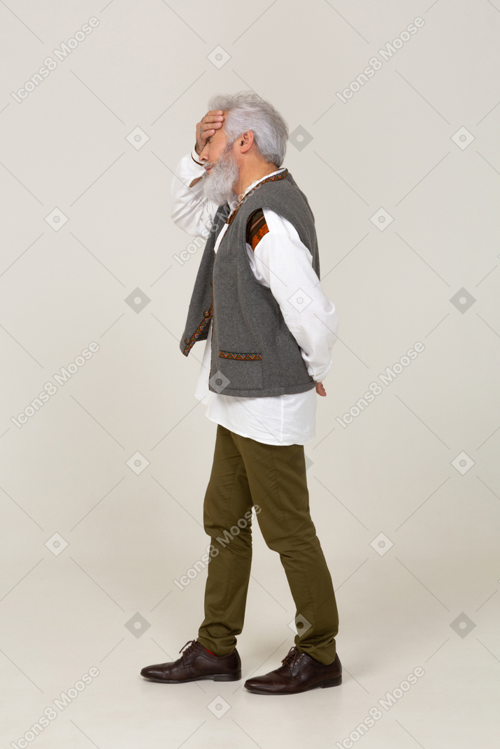 Man in gray vest slapping his forehead