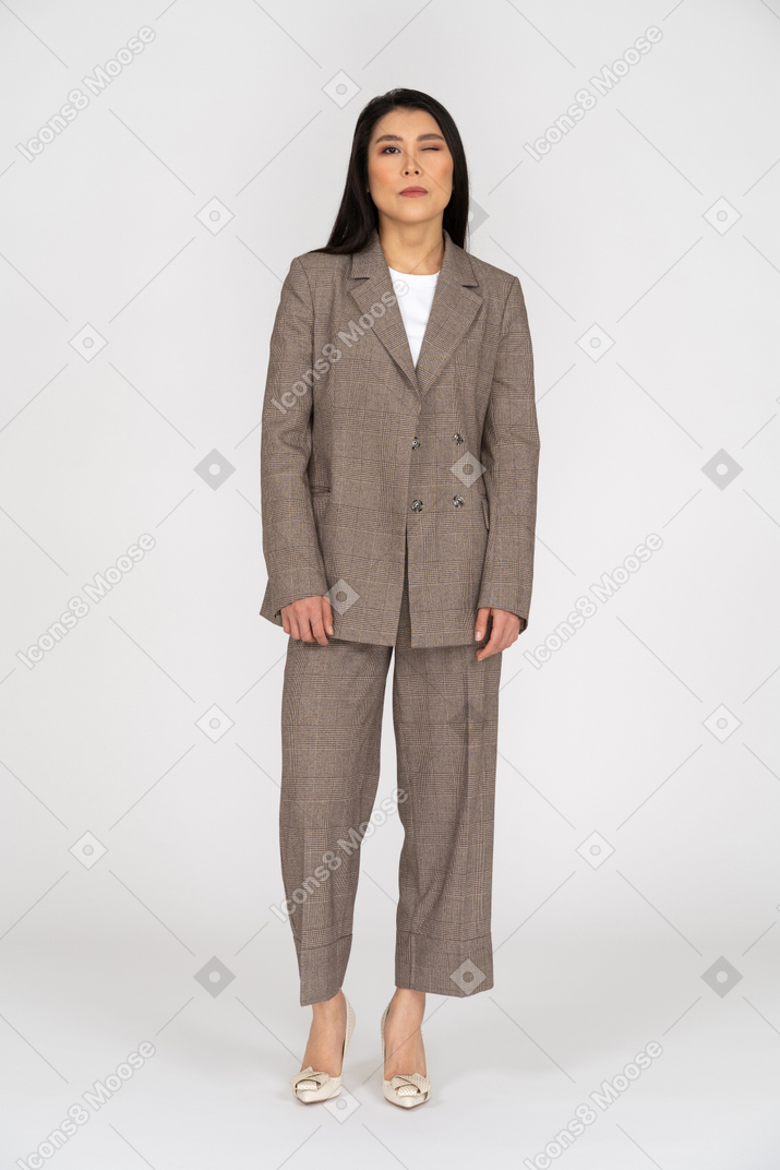 茶色のビジネススーツでまばたきの若い女性の正面図