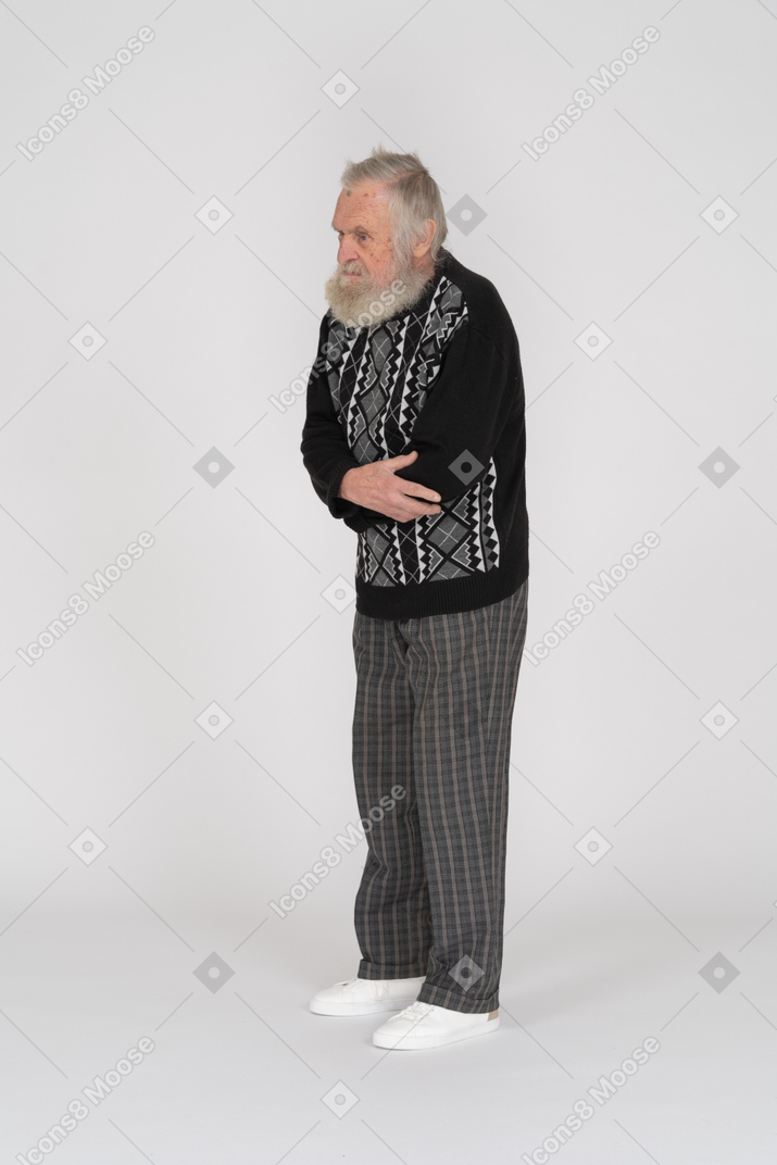 Uomo anziano in piedi con le braccia conserte