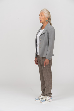 Side view of an impressed old woman in suit