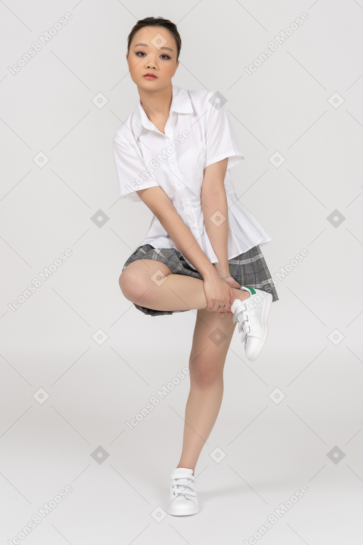A confident asian girl lifting her one leg to her hip