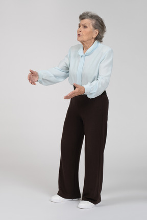 Three-quarter view of an old woman gesturing expressively