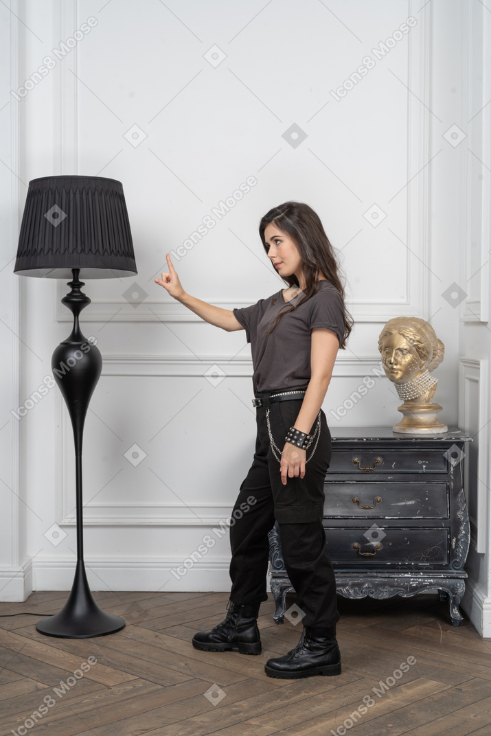 Vista de tres cuartos de una mujer rockera mostrando un gesto de advertencia