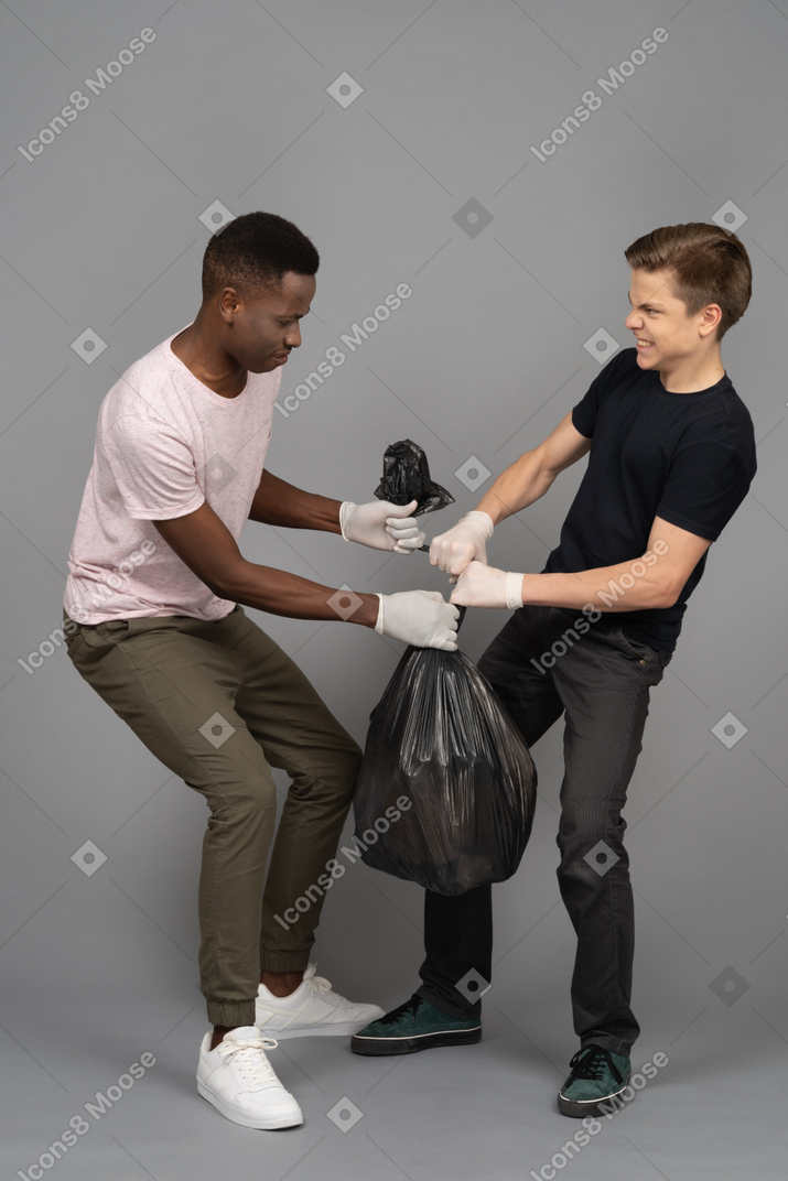 Two friends fighting for a trash bag