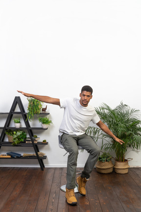 Good looking young man posing on the background of the apartment