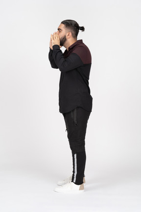 Side view of a young man with a bun shouting